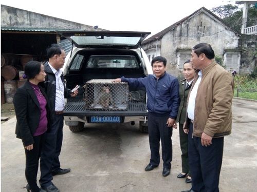 A group of people standing around a car
Description automatically generated