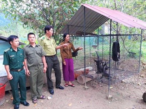 A group of people standing next to a cage
Description automatically generated