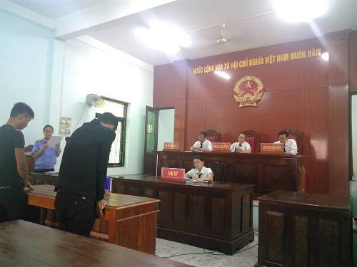 A group of people in a courtroom

Description automatically generated