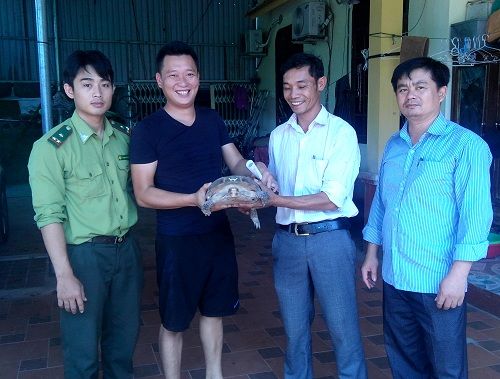 A group of men holding a animal Description automatically generated