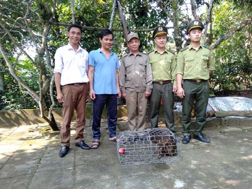A group of men standing in front of a cage with a dog
Description automatically generated