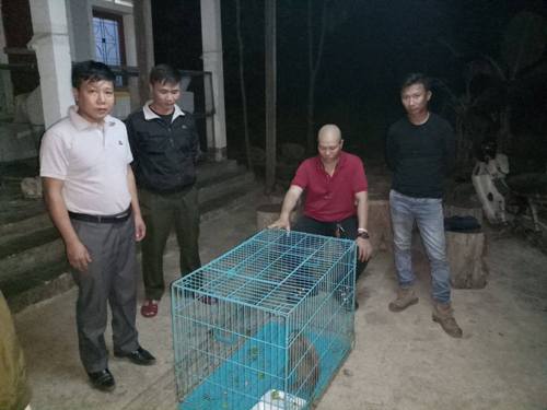A group of men standing next to a cage
Description automatically generated