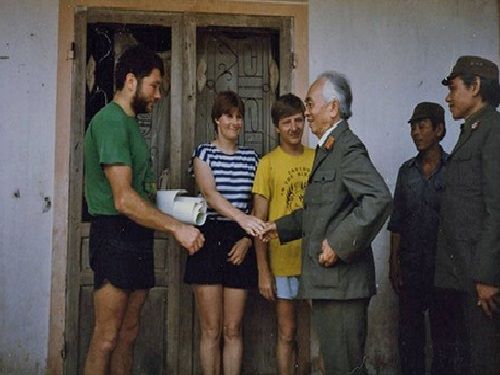 A group of people standing outside a door Description automatically generated