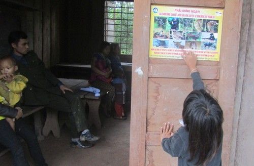 A child reaching out to a sign

Description automatically generated