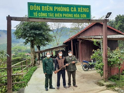 A group of people wearing face masks standing in front of a sign Description automatically generated
