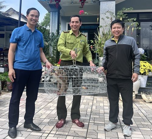 A group of men holding a cage with a raccoon in it
Description automatically generated