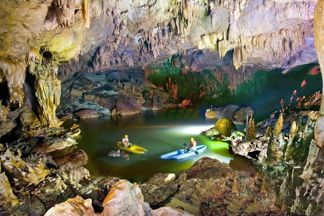 People kayaking in a cave Description automatically generated