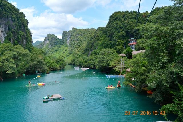 A river with boats and trees Description automatically generated