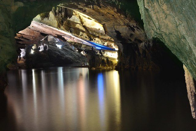 A cave with water and lights Description automatically generated