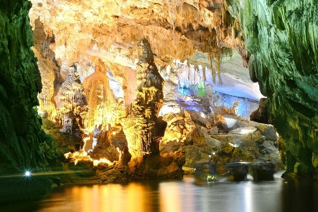 A cave with a body of water Description automatically generated