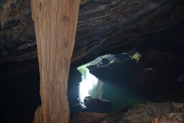 A cave with water and rocks Description automatically generated