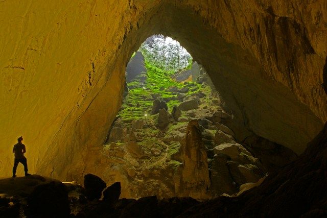 A cave with a light in the ground Description automatically generated