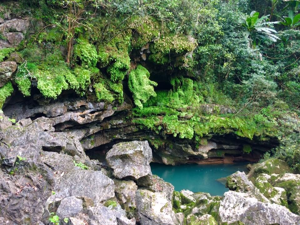 A small pond surrounded by rocks Description automatically generated