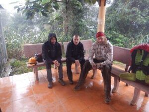 A group of men sitting on a bench Description automatically generated