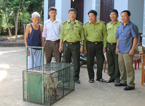 A group of men standing next to a cage

Description automatically generated
