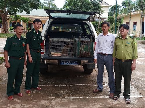 A group of men standing next to a car Description automatically generated