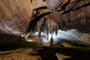 A cave with stalactites and stalagmites Description automatically generated